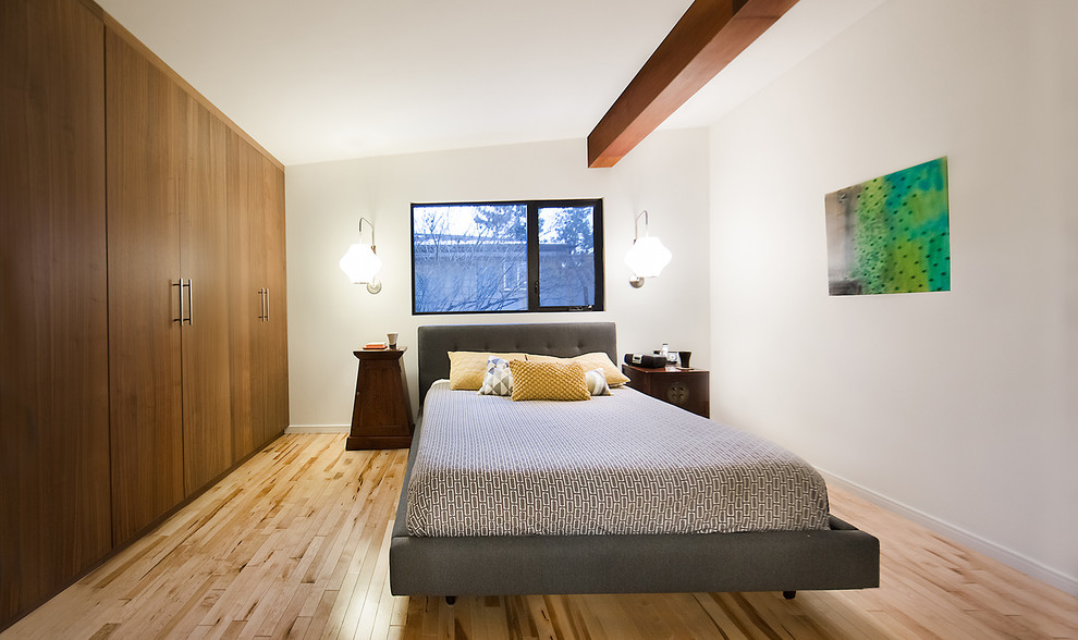 Imagen de dormitorio actual de tamaño medio con paredes blancas, suelo de madera en tonos medios y suelo marrón