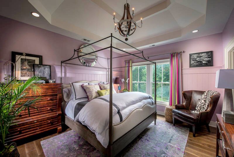 Diseño de habitación de invitados bohemia de tamaño medio sin chimenea con paredes púrpuras y suelo de madera en tonos medios