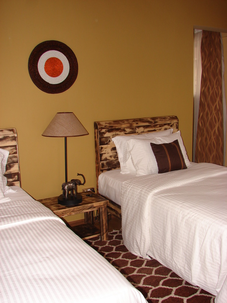 Imagen de habitación de invitados exótica sin chimenea con paredes marrones y suelo laminado