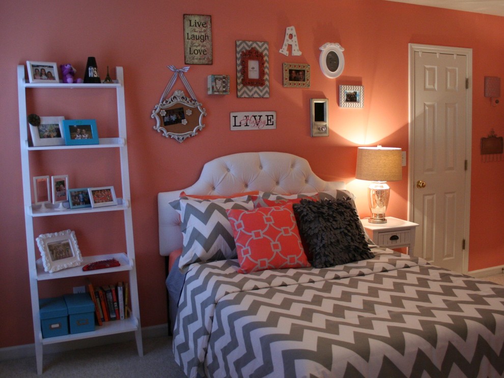 Immagine di una camera da letto chic con pareti arancioni e moquette
