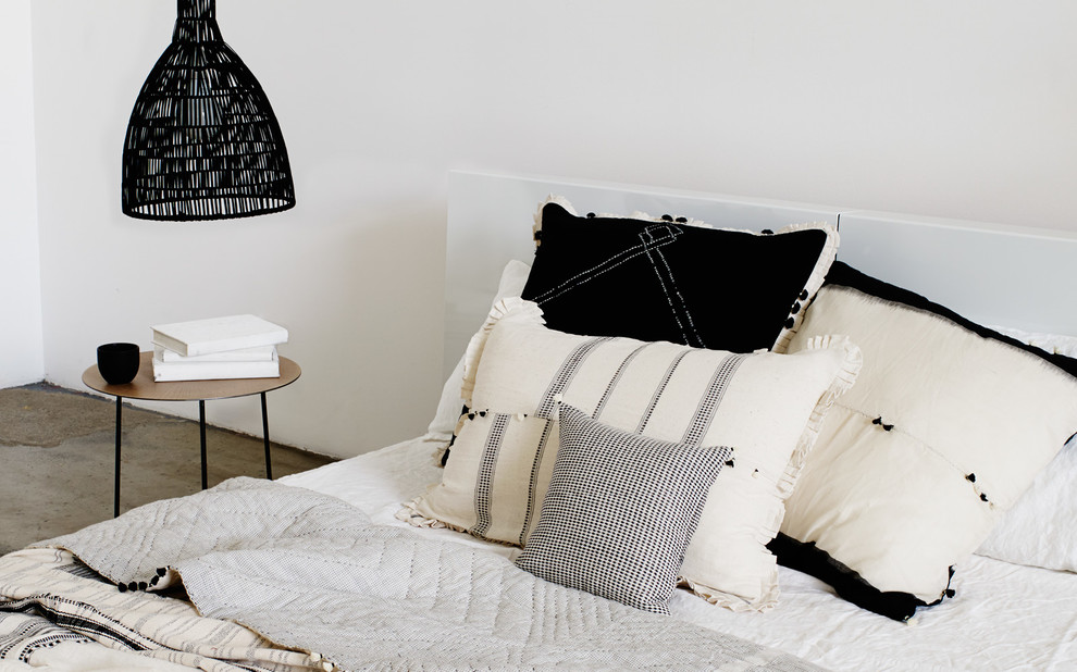 На фото: большая спальня на антресоли в стиле модернизм с белыми стенами, бетонным полом, стандартным камином и фасадом камина из штукатурки
