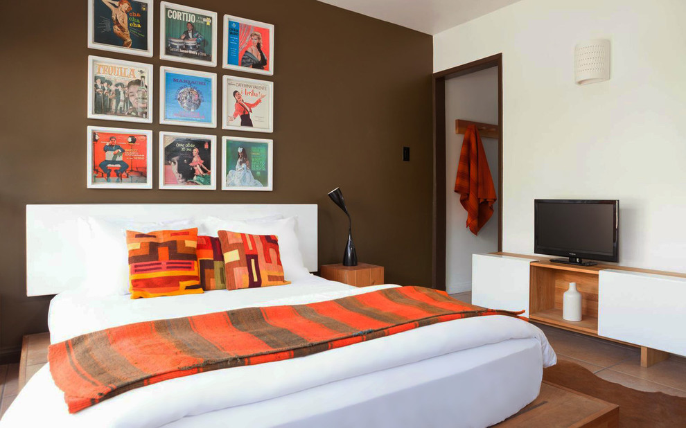 Ejemplo de habitación de invitados de estilo americano de tamaño medio sin chimenea con paredes marrones y suelo de baldosas de terracota
