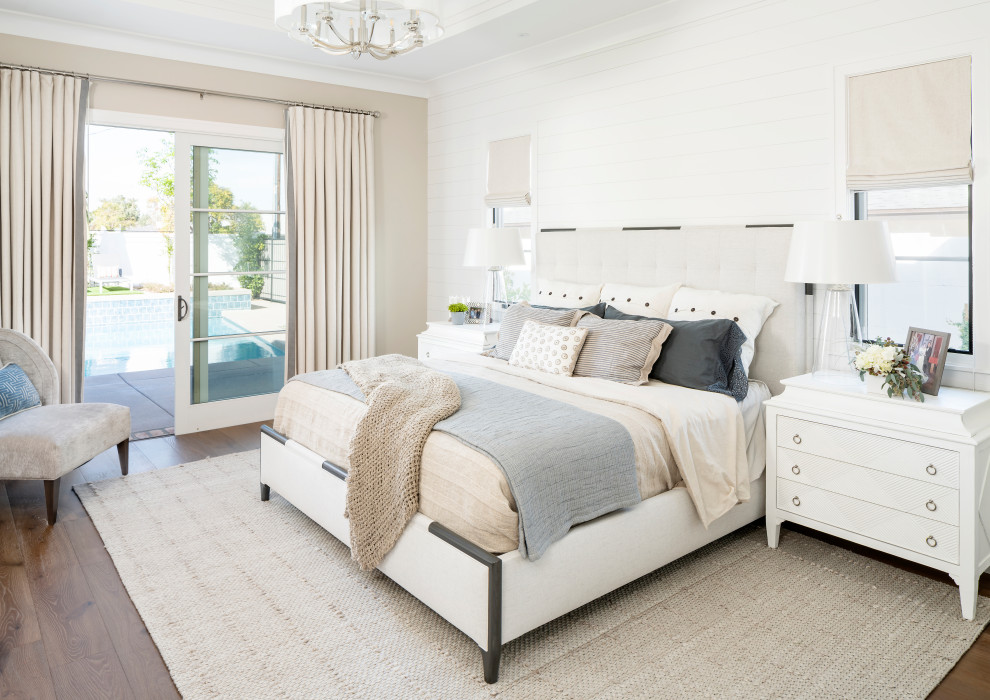 Foto de dormitorio principal costero sin chimenea con paredes blancas y suelo de madera en tonos medios