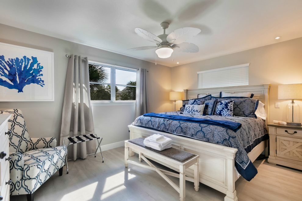 Coastal guest and grey and cream bedroom in Miami with beige walls, light hardwood flooring, no fireplace and beige floors.