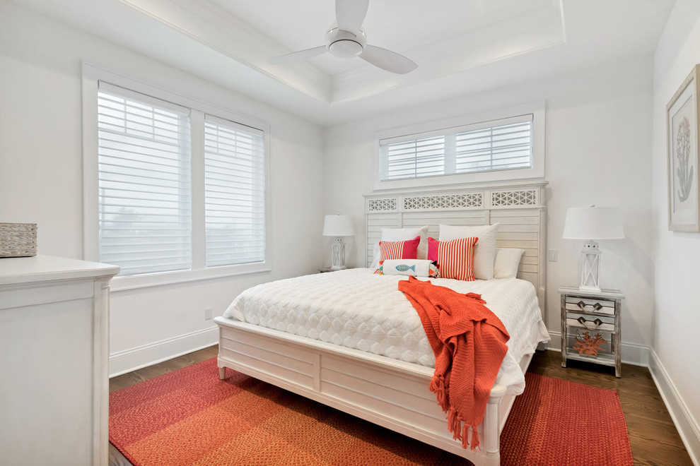 Immagine di una camera degli ospiti costiera con pavimento in legno massello medio e pareti bianche