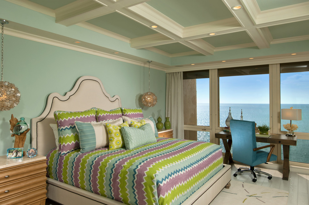 Immagine di una camera da letto tropicale con pareti blu e parquet chiaro