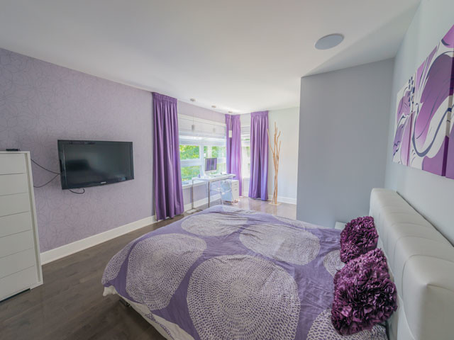 Diseño de habitación de invitados actual de tamaño medio con paredes púrpuras y suelo de madera oscura
