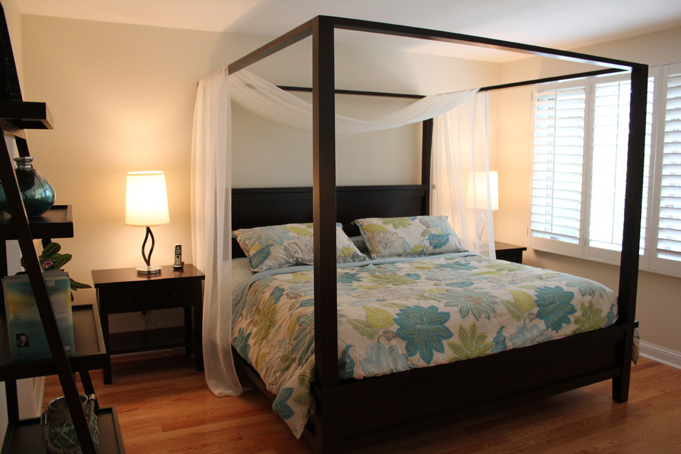 Inspiration for a beach style master bedroom in Toronto with white walls and medium hardwood flooring.
