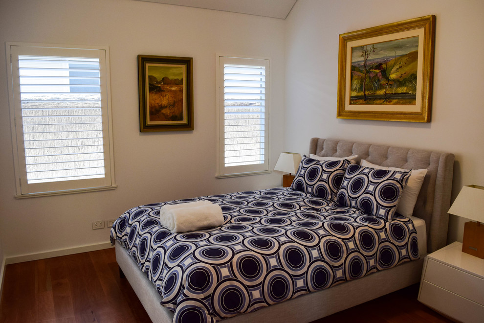 Imagen de habitación de invitados clásica renovada de tamaño medio sin chimenea con paredes blancas, suelo de madera oscura y suelo marrón