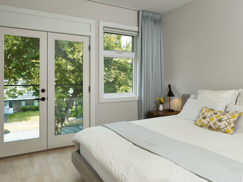 Modernes Schlafzimmer ohne Kamin mit grauer Wandfarbe und hellem Holzboden in Vancouver