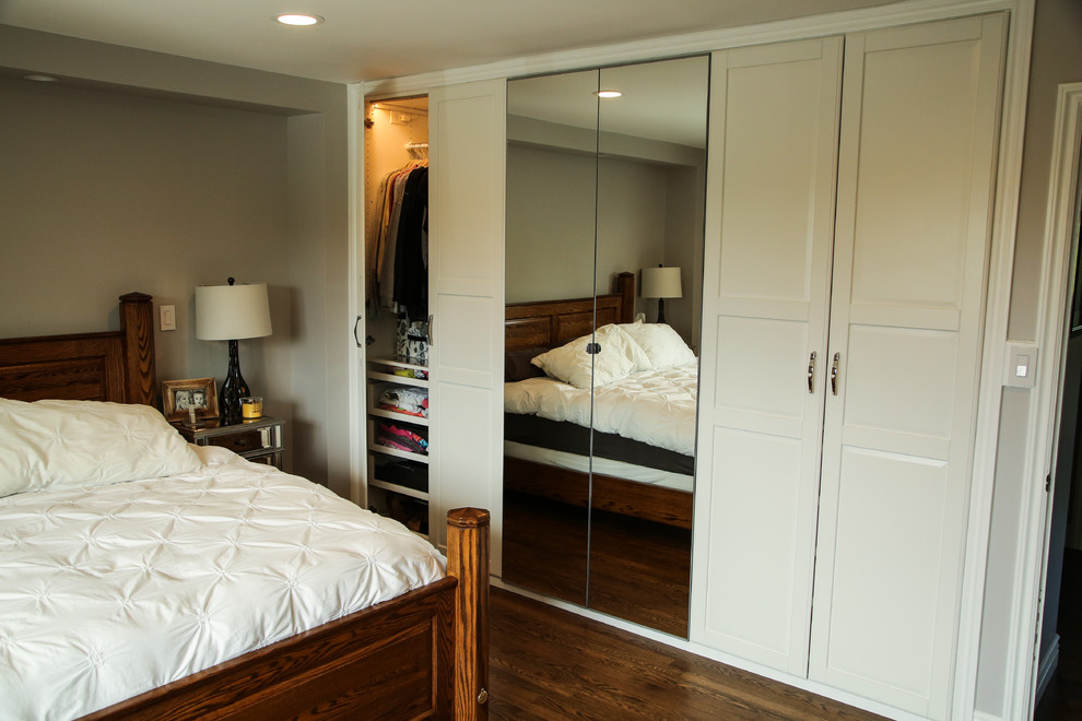 Diseño de dormitorio principal tradicional renovado de tamaño medio sin chimenea con paredes grises, suelo de madera oscura y suelo marrón