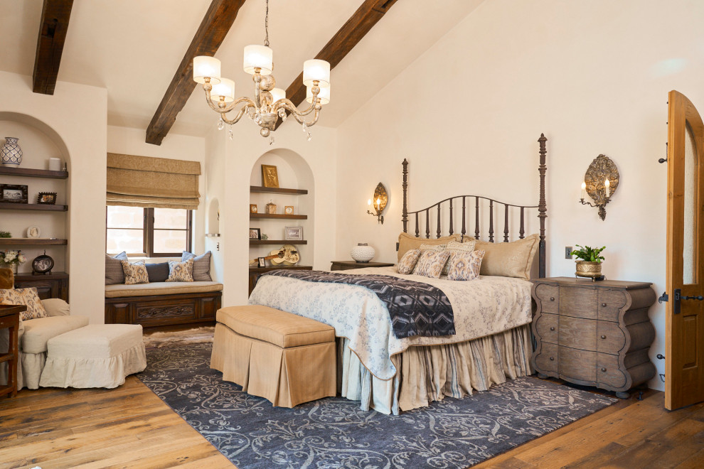 ウィチタにあるサンタフェスタイルのおしゃれな寝室 (ベージュの壁、無垢フローリング、茶色い床、表し梁、三角天井) のインテリア