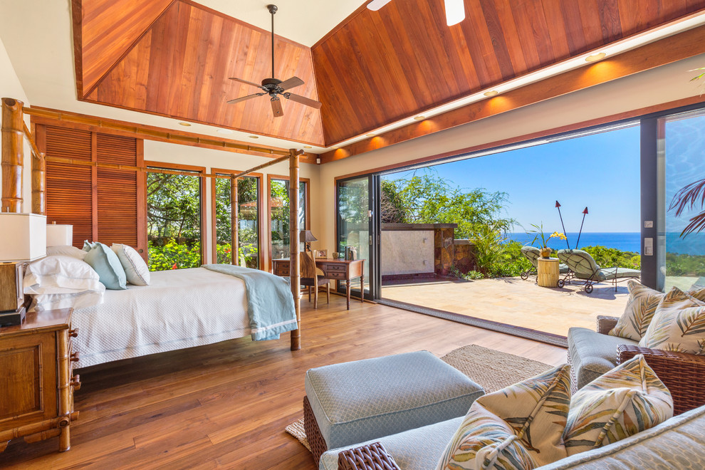Mittelgroßes Hauptschlafzimmer ohne Kamin mit beiger Wandfarbe, braunem Holzboden und braunem Boden in Hawaii