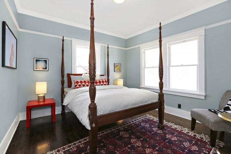 Immagine di una camera da letto stile americano di medie dimensioni con pareti grigie, parquet scuro, nessun camino e pavimento marrone