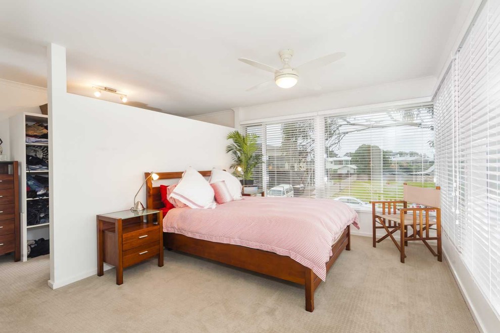 This is an example of a medium sized midcentury master bedroom in Melbourne with white walls, no fireplace and carpet.
