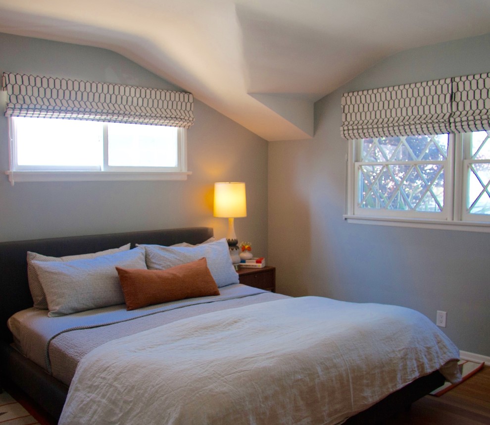 Small retro master bedroom in Los Angeles with blue walls, medium hardwood flooring and brown floors.