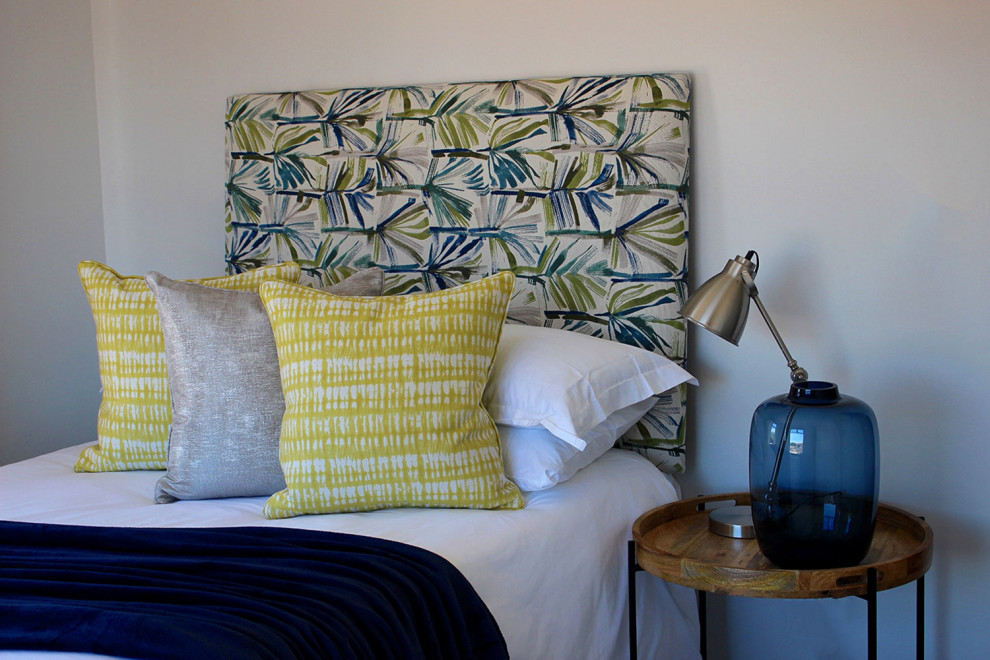 Immagine di una camera degli ospiti mediterranea di medie dimensioni con pareti gialle, parquet chiaro e pavimento grigio