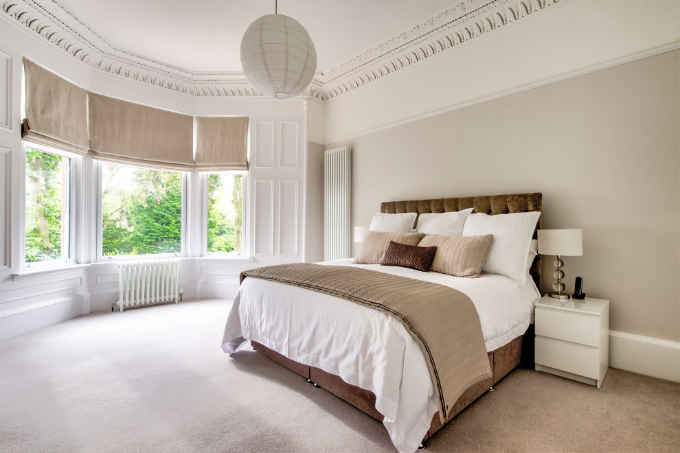 Large traditional master bedroom in Glasgow with beige walls, carpet and beige floors.