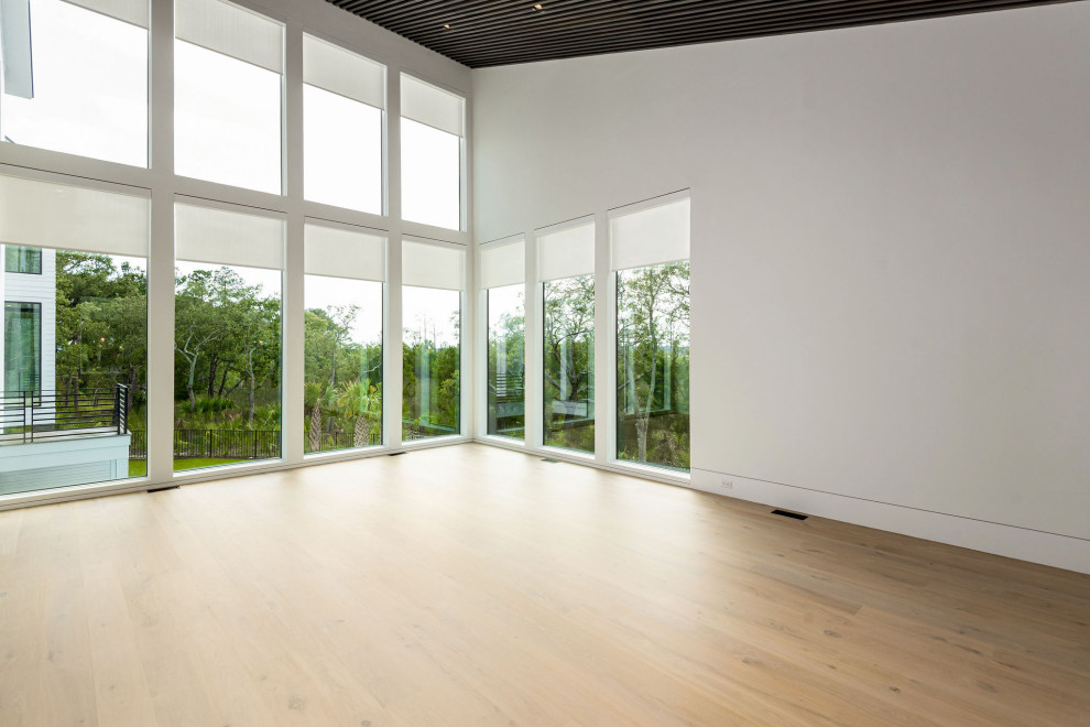 Geräumiges Modernes Hauptschlafzimmer mit bunten Wänden, hellem Holzboden, beigem Boden, Holzdecke und Holzwänden in Charleston