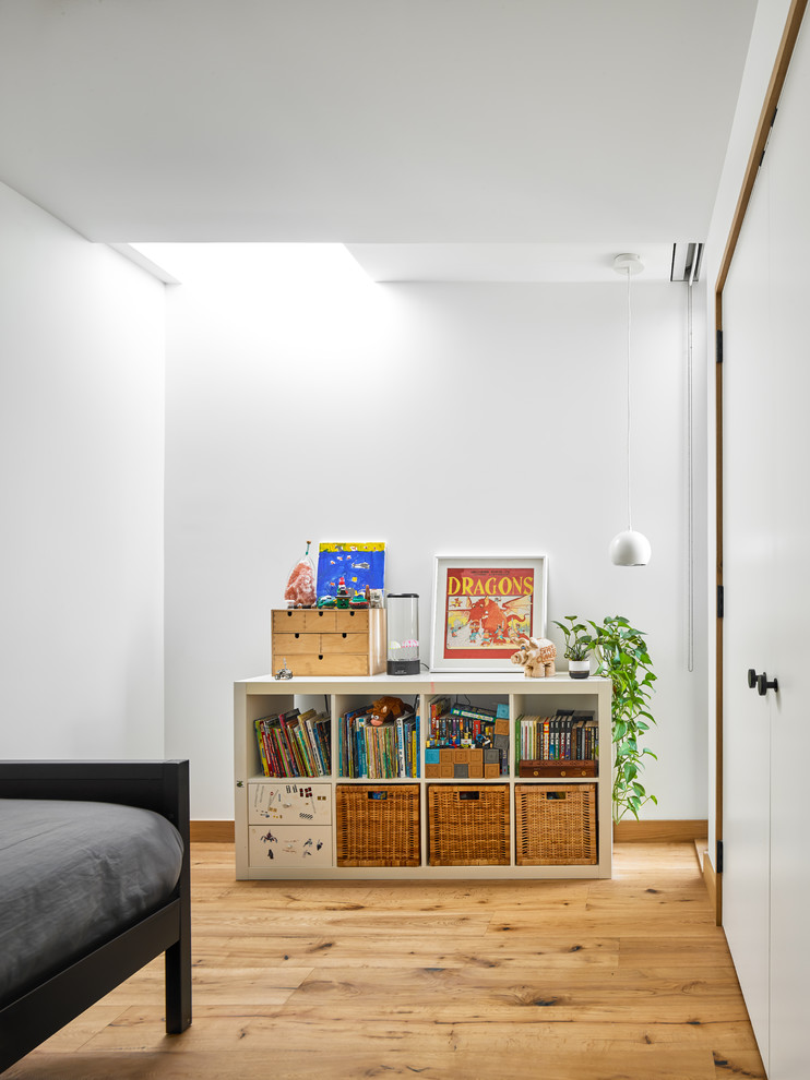 Inspiration för ett litet minimalistiskt gästrum, med vita väggar, ljust trägolv och brunt golv
