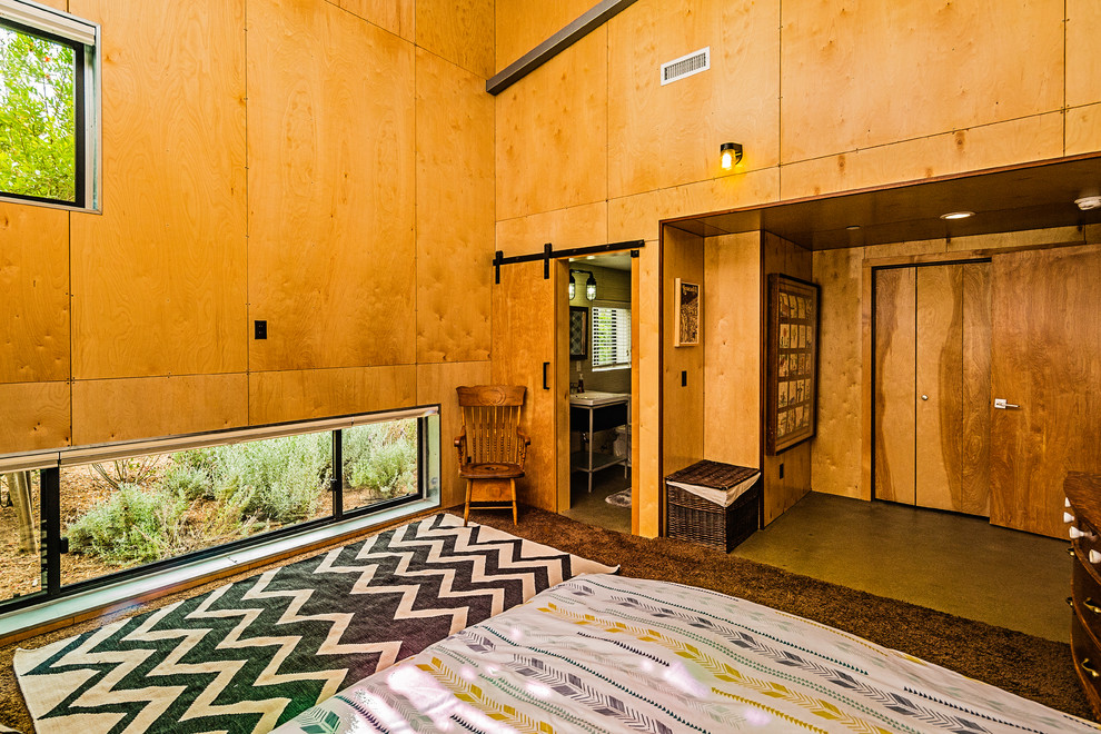 На фото: гостевая спальня среднего размера, (комната для гостей) в стиле ретро с желтыми стенами, бетонным полом и серым полом без камина