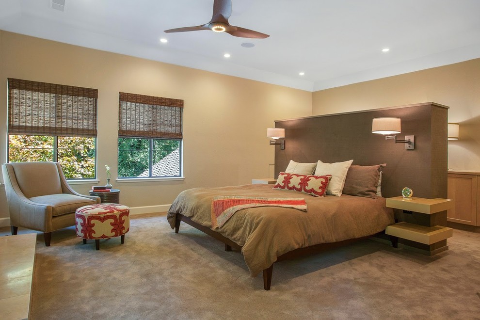 This is an example of a large contemporary master bedroom in San Francisco with beige walls, carpet, a standard fireplace and a stone fireplace surround.