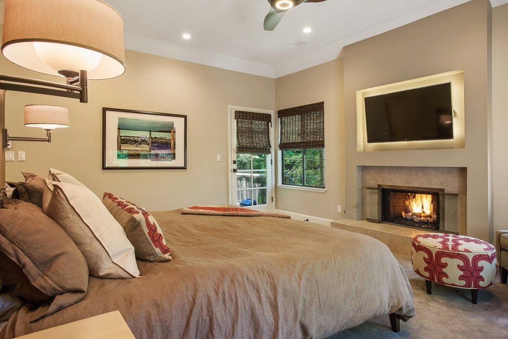 Exemple d'une grande chambre tendance avec un mur beige, une cheminée standard et un manteau de cheminée en pierre.