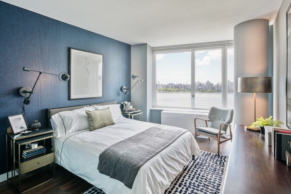 Diseño de dormitorio actual sin chimenea con paredes azules y suelo de madera oscura