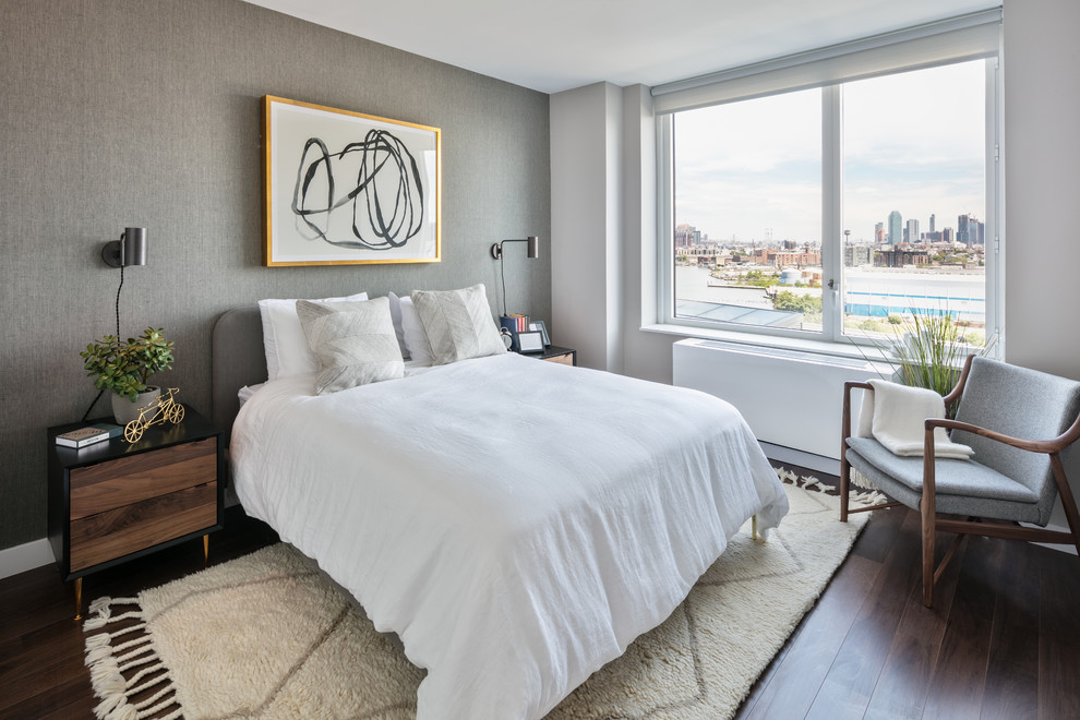 Modernes Schlafzimmer ohne Kamin mit grauer Wandfarbe und dunklem Holzboden in New York