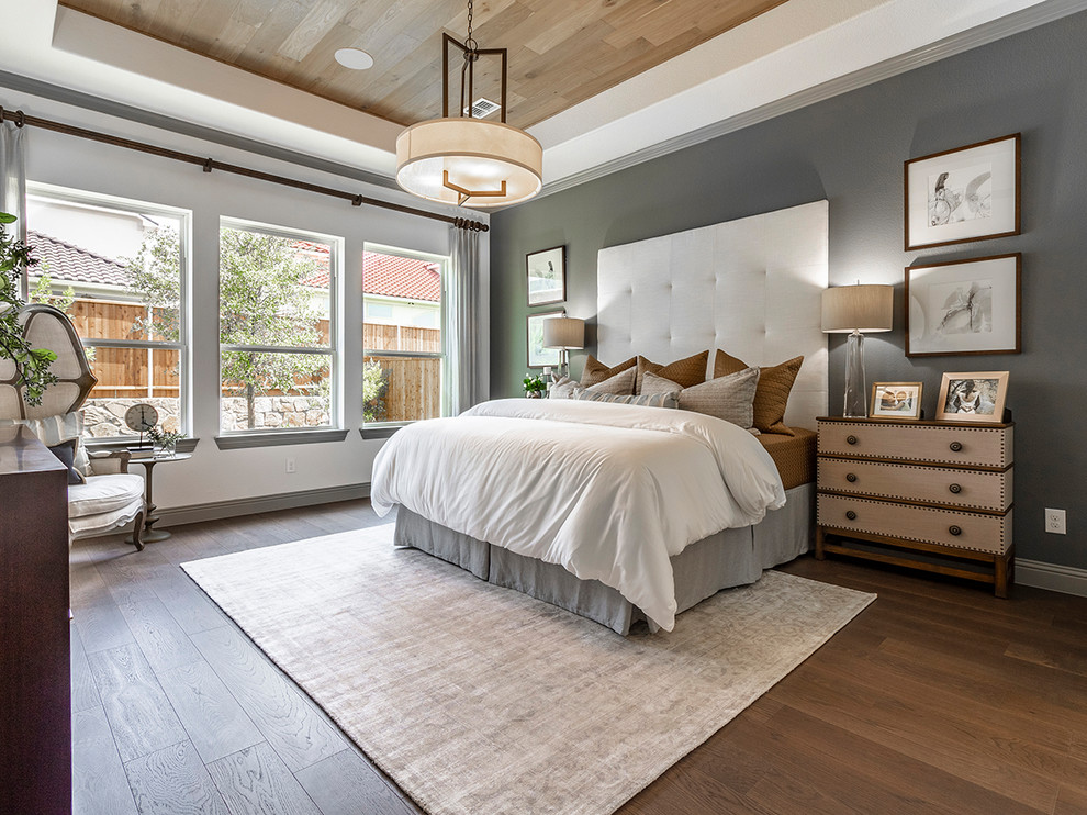 Traditional master and grey and brown bedroom in Dallas with white walls, dark hardwood flooring and brown floors.