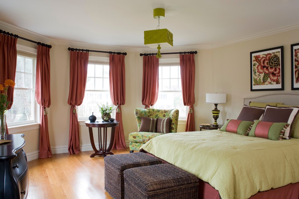 Imagen de dormitorio tropical de tamaño medio con paredes beige y suelo de madera clara