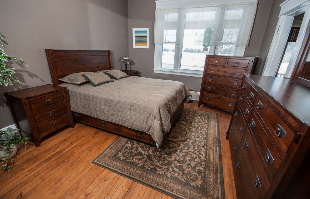 Aménagement d'une chambre montagne de taille moyenne avec un mur gris et un sol en bois brun.