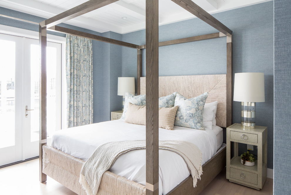 Idee per una camera da letto stile marino con pareti blu e parquet chiaro