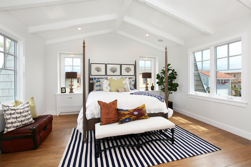 Maritimes Gästezimmer ohne Kamin mit weißer Wandfarbe und braunem Holzboden in Orange County