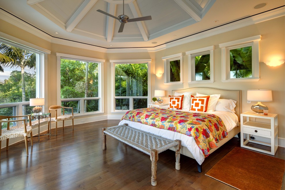 Ejemplo de dormitorio principal tropical con paredes beige y suelo de madera en tonos medios