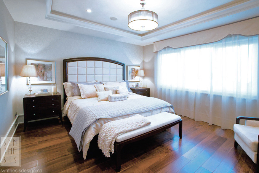 Immagine di una camera matrimoniale chic di medie dimensioni con pareti grigie e pavimento in legno massello medio