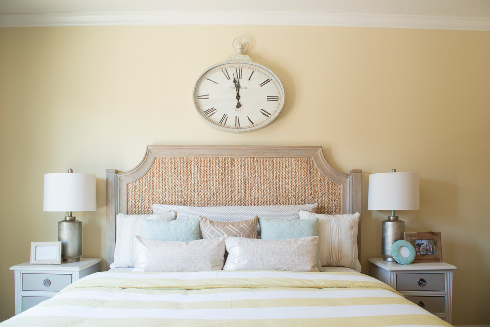 Imagen de dormitorio principal costero de tamaño medio con paredes amarillas y suelo de madera oscura