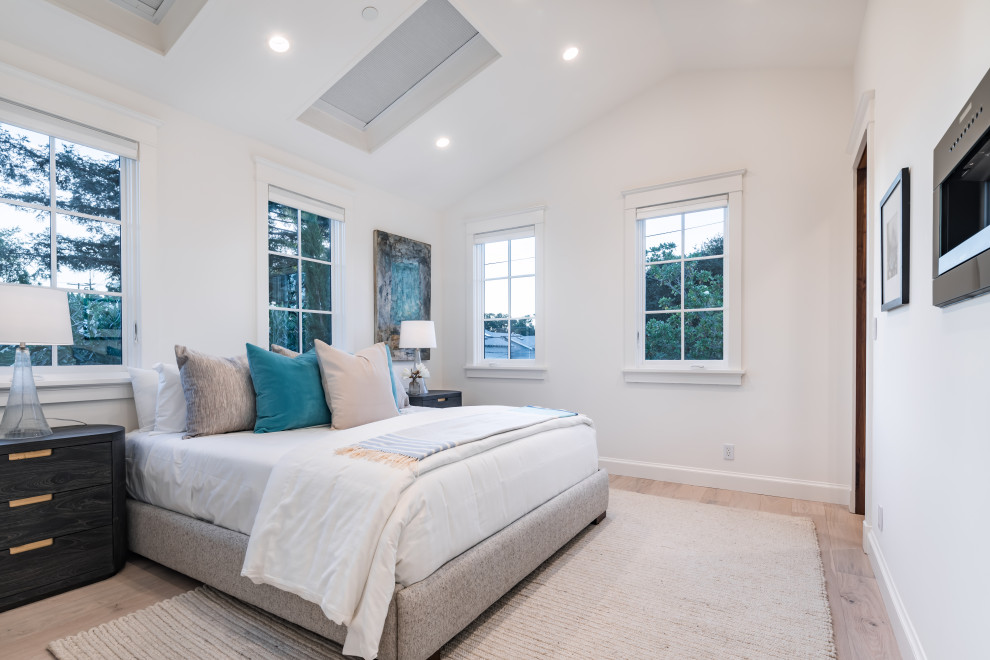 Foto de dormitorio principal y abovedado tradicional renovado de tamaño medio sin chimenea con paredes blancas, suelo de madera clara y suelo beige