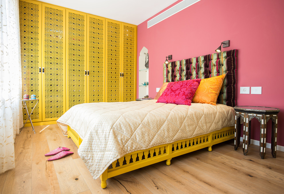Modelo de dormitorio de estilo zen con paredes rosas y suelo de madera clara