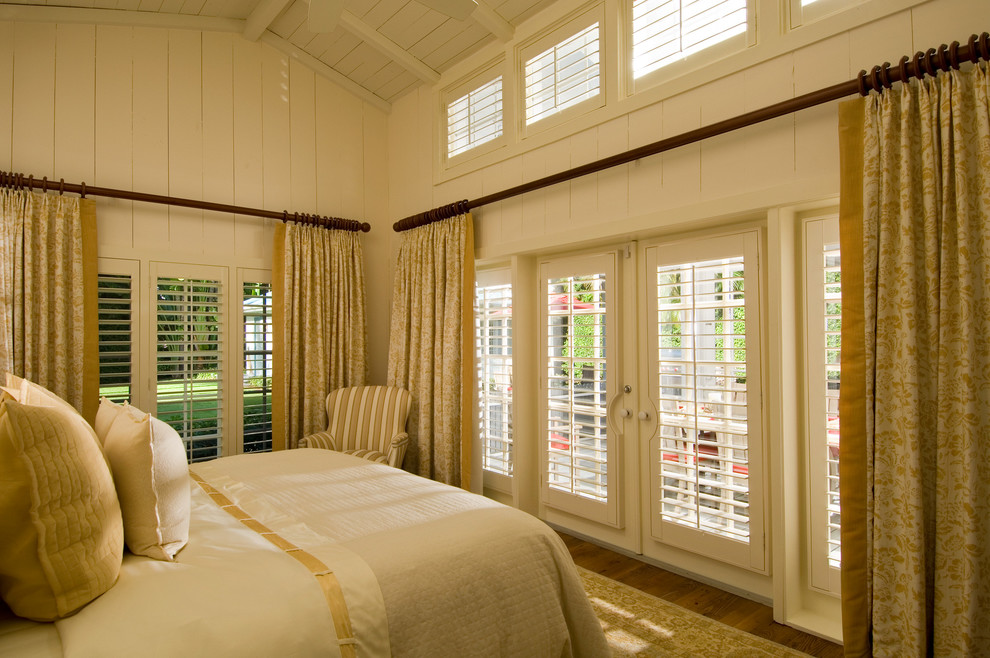 Idee per una camera da letto costiera di medie dimensioni con pareti bianche, pavimento in legno massello medio, nessun camino e pavimento marrone