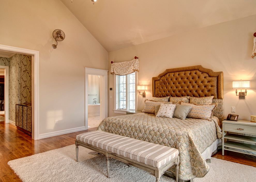 Idée de décoration pour une chambre tradition avec un mur beige et un sol en bois brun.