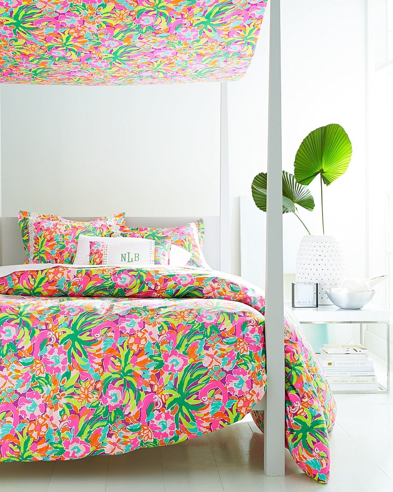 Immagine di una camera da letto tropicale con pareti bianche e pavimento in legno verniciato