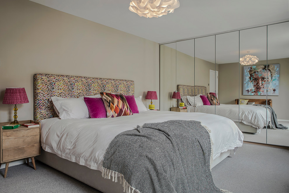 Inspiration for a contemporary master and grey and pink bedroom in London with beige walls, carpet and grey floors.