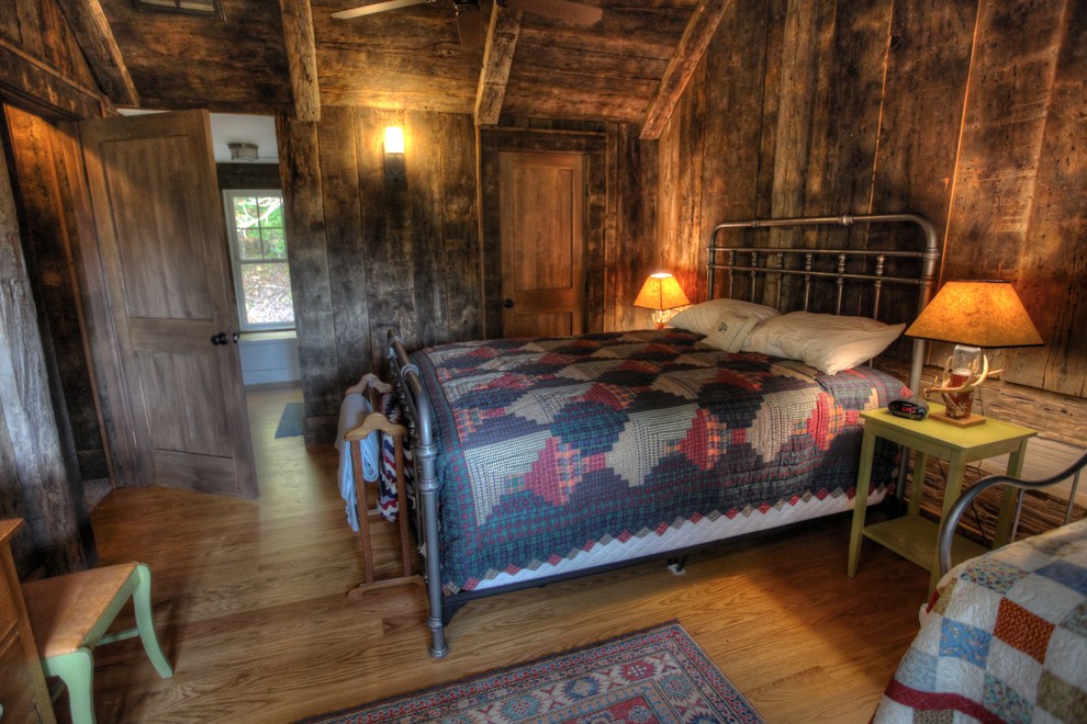 Modelo de habitación de invitados rústica de tamaño medio sin chimenea con paredes marrones y suelo de madera clara