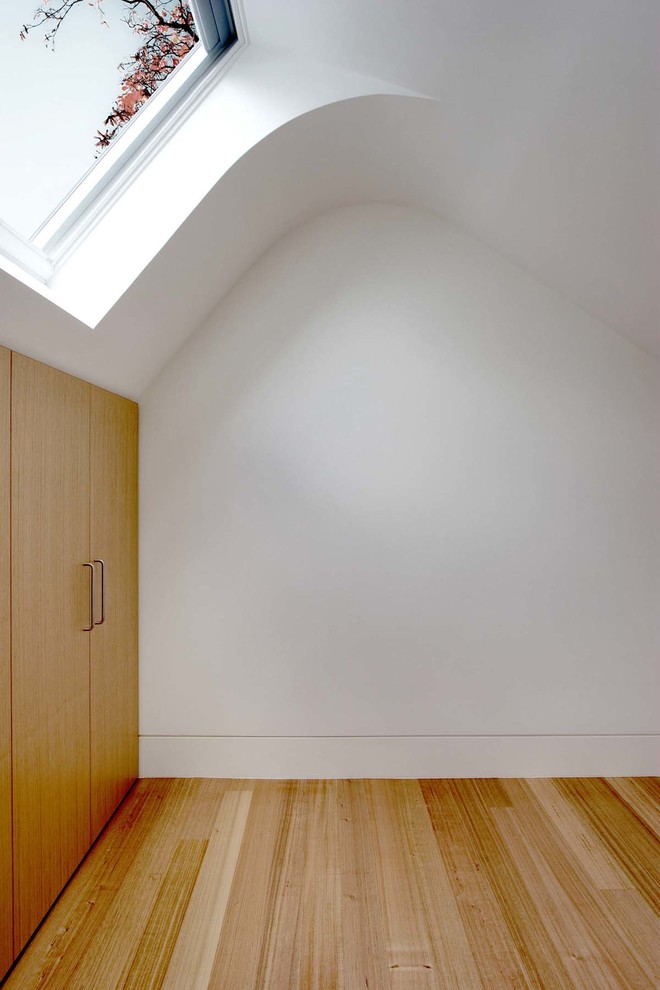 Ispirazione per una piccola camera da letto design con pareti bianche, parquet chiaro e nessun camino