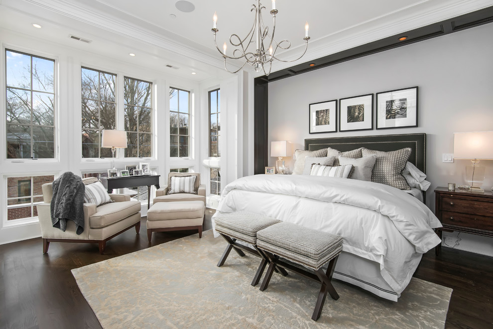 Inspiration for a large classic master bedroom in Chicago with beige walls, dark hardwood flooring, a standard fireplace, a stone fireplace surround and feature lighting.