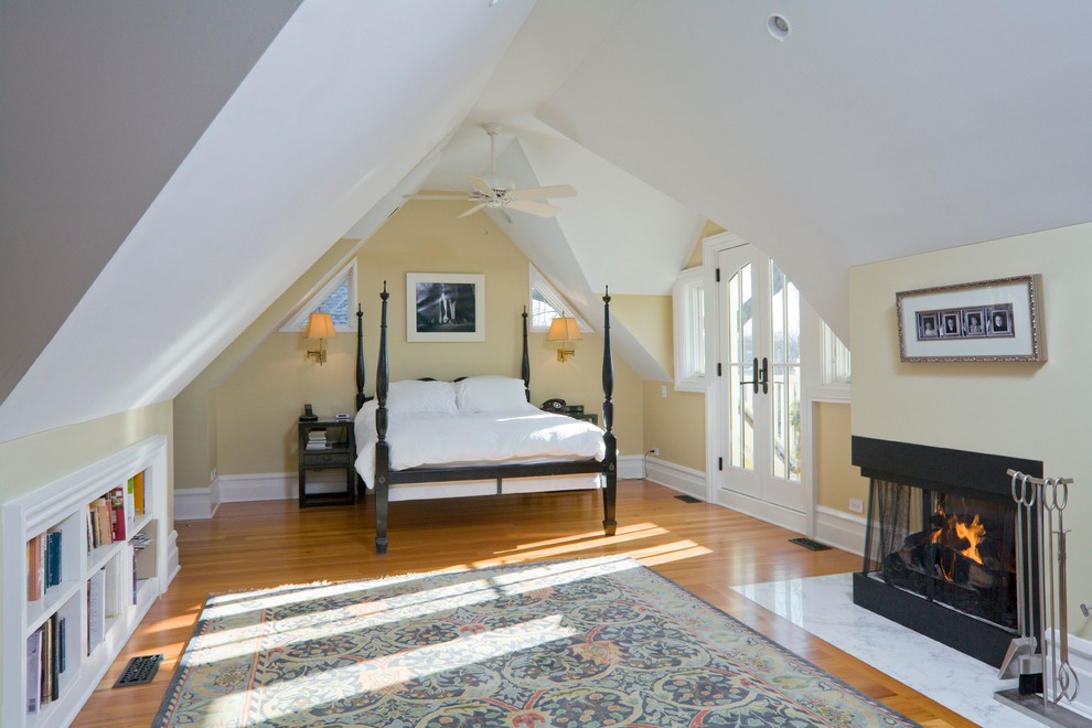 Foto di una camera da letto stile loft tradizionale di medie dimensioni con pareti beige, pavimento in legno massello medio, camino ad angolo e cornice del camino piastrellata