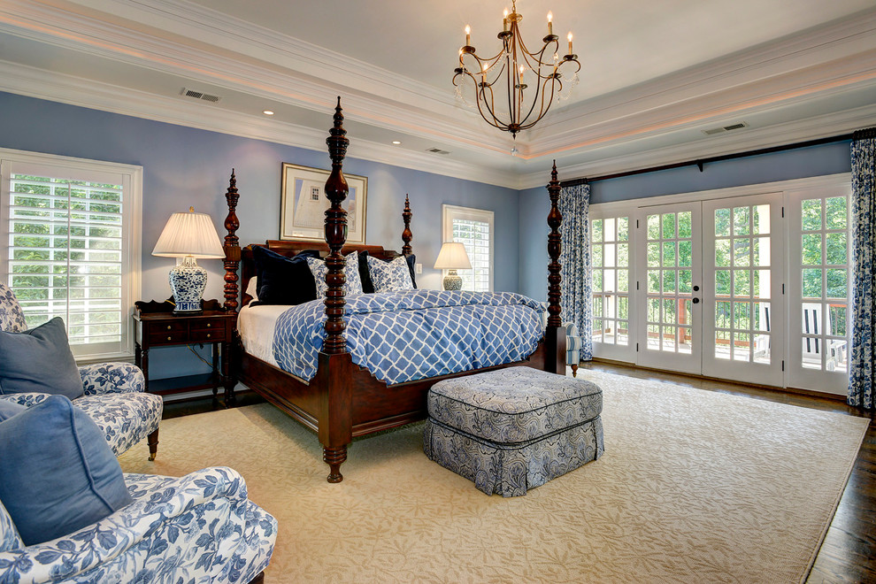 Cette image montre une chambre parentale traditionnelle avec un mur bleu et un sol en bois brun.
