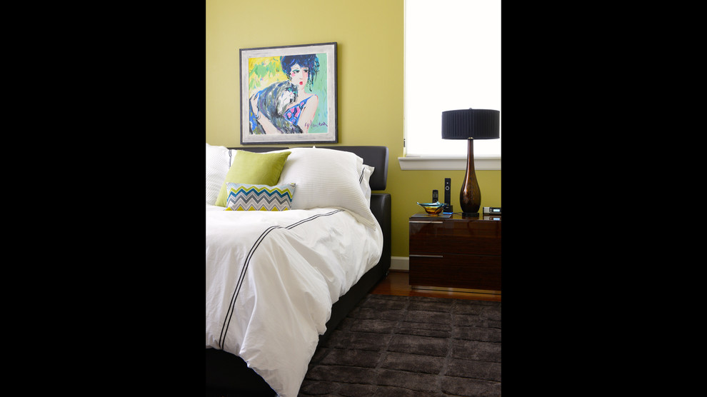 Ejemplo de dormitorio moderno grande sin chimenea con paredes amarillas y suelo de madera oscura