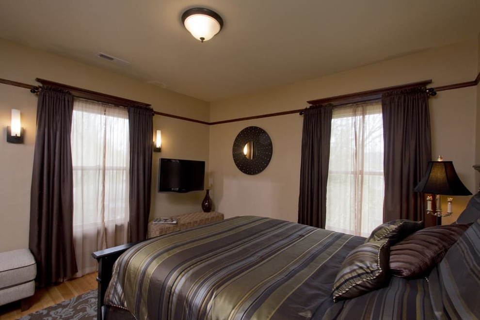Inspiration for a large craftsman master light wood floor bedroom remodel in Portland with beige walls